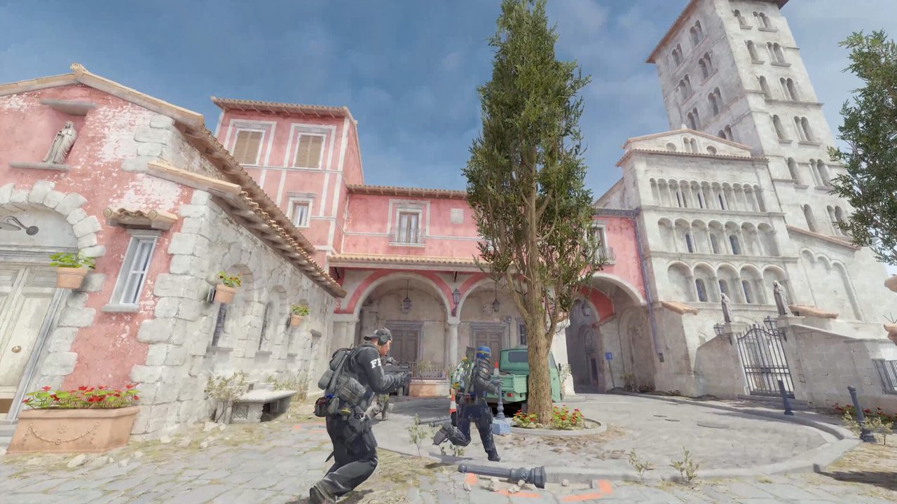Two players moving through a pink-plastered Italian courtyard map next to a large tree and a parked green truck.